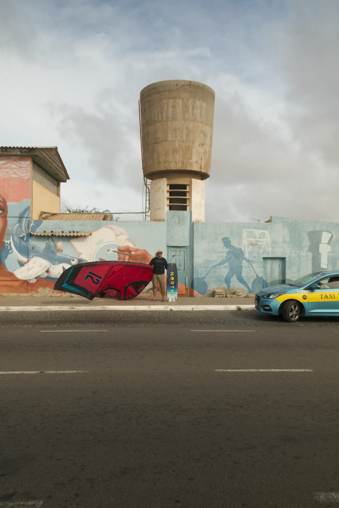 Koen Darras with North Kiteboarding gear in front of ocean mural